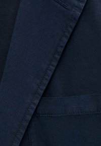 Marinblått tyg med slät textur och en subtil lyster. Inkluderar en framficka med prydlig sömnad och en rak skärning.