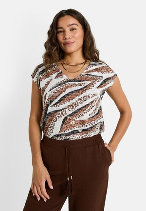 Top à manches courtes dans un mélange de motifs animaliers blancs et marron, avec un décolleté en V et une coupe décontractée, associé à un pantalon marron à taille élastique.