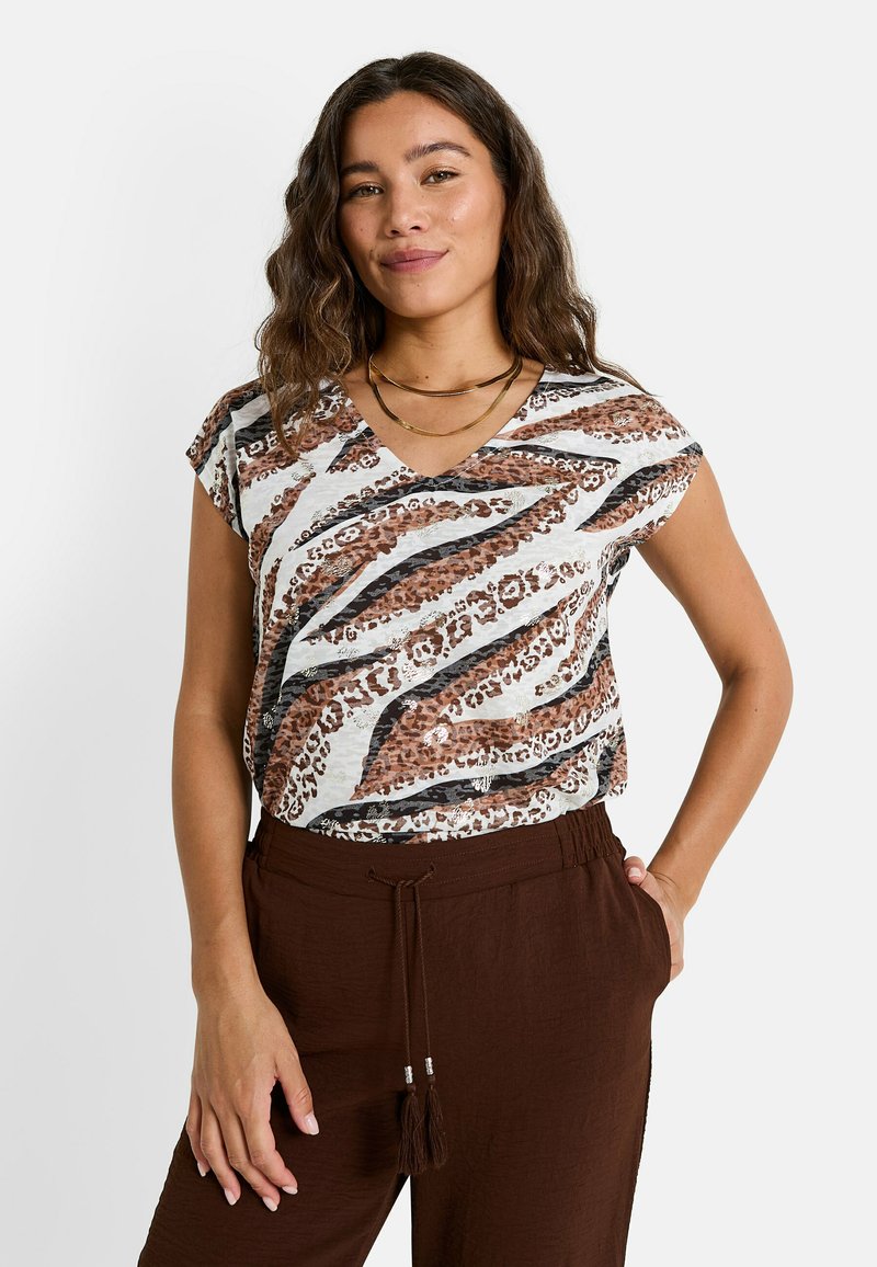 Top de manga corta en una mezcla de estampado animal en blanco y marrón, con escote en V y un corte relajado, combinado con pantalones de cintura elástica marrones.