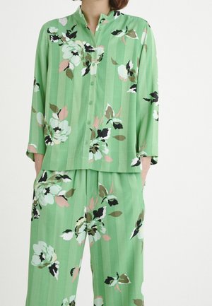 Ensemble de détente à imprimé floral vert avec un haut à boutons et col mandarin, accompagné d'un pantalon ample, tous deux avec une texture rayée.