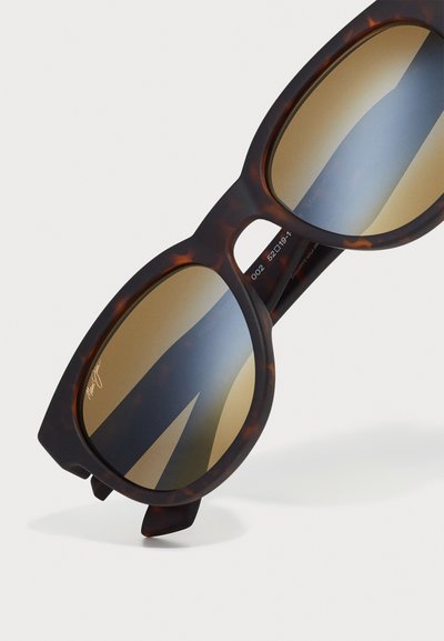 Lunettes de soleil en écaille de tortue avec des verres arrondis surdimensionnés ; teinte dégradée brune ; montures épaisses avec une finition lisse et un subtil détail découpé.