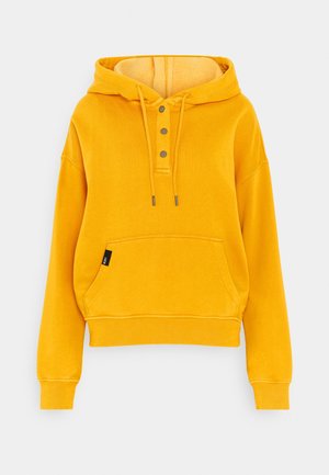 Sweat à capuche jaune vif avec cordons, trois boutons métalliques sur le devant, poche kangourou et poignets et bas côtelés.