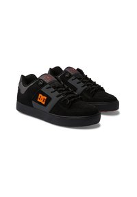 Black skate shoes with a suede and mesh upper, featuring a gray side panel, orange logo, and black rubber sole. Laces and padded tongue included.
