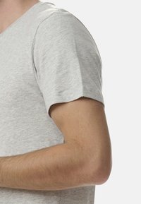 Szary t-shirt z dekoltem w serek i krótkimi rękawami, wykonany z miękkiej tkaniny. Posiada prosty design o gładkiej teksturze, bez widocznych wzorów ani akcentów.