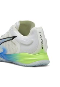 Scarpa da corsa bianca con tomaia in mesh testurizzata, suola gradientata blu chiaro e verde, e dettagli neri sui lati. "ACCELERATE" stampato sul tallone.