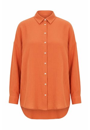 Oranssi, pitkähihainen, napitettava paitapusero, jossa on kaulus, teksturoitu kangas ja takaa pidempi kaareva helma.