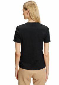 T-shirt nera a maniche corte con scollatura tonda, texture liscia e silhuette aderente, mostrata da dietro con dettagli minimi.