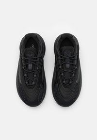 Zapatillas deportivas negras con una parte superior sintética suave, acentos texturizados, diseño de cordones y un collar acolchado para mayor comodidad.