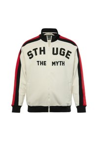 Giacca bianca con zip e la scritta "STHUGE THE MYTH" in font nero. Presenta maniche a righe rosse e nere, polsini a coste e colletto rialzato.