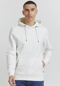 Witte hoodie van zachte stof, met een voorzak, een capuchon met trekkoord en zwarte accenten, en geribde manchetten voor een goede pasvorm.