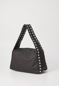 Black fabric handbag with a wide, patterned strap featuring silver studs along the sides and a structured, angular shape.