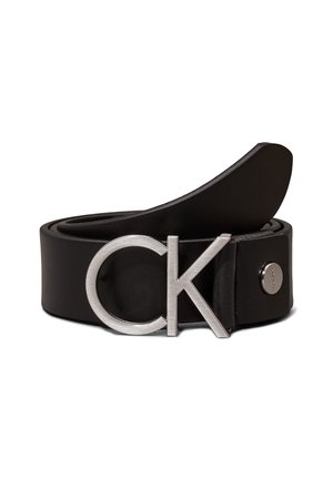 Schwarzer Ledergürtel aufgerollt mit silberner "cK"-Schnalle und kleinem rundem Metallknopf auf weißem Hintergrund.