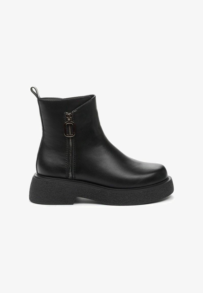 Botas negras de tobillo hechas de cuero suave con cremallera lateral, suela de goma texturizada y punta redonda, con un diseño minimalista.
