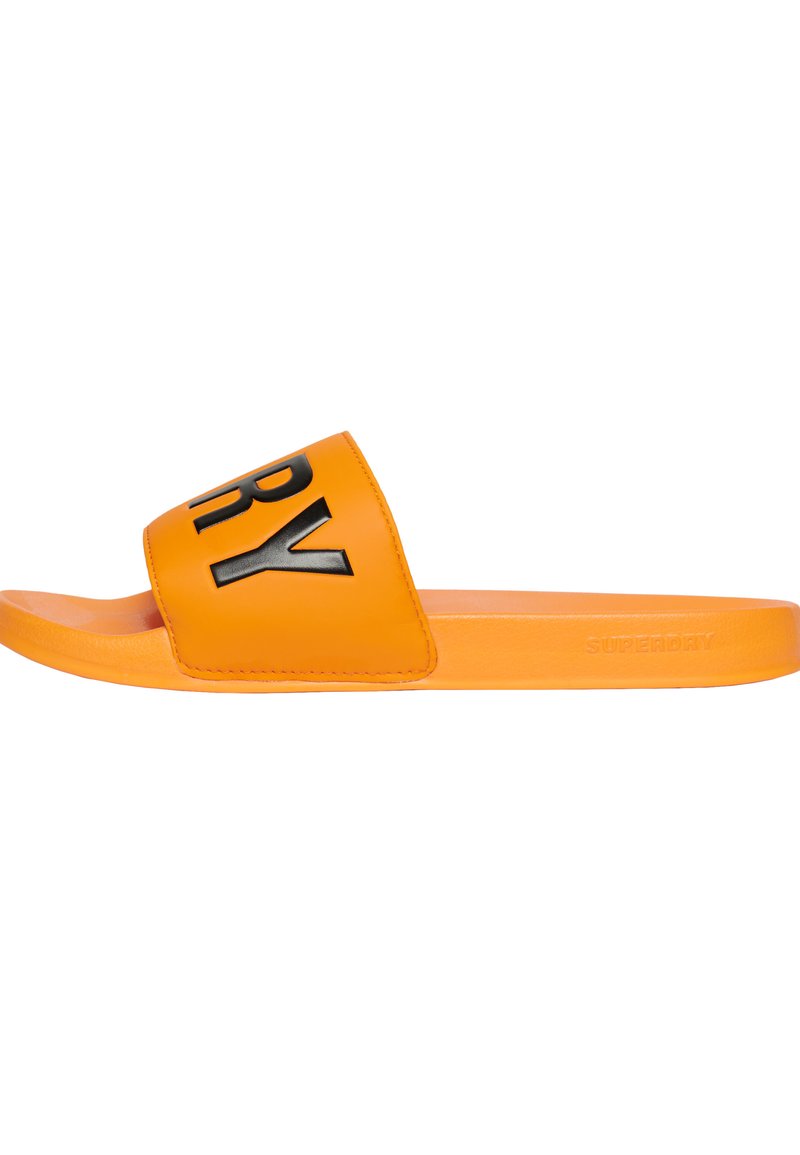 Oranje slipper met een brede band met zwarte letters. Gladde textuur, platte zool en reliëf logo detail aan de zijkant.