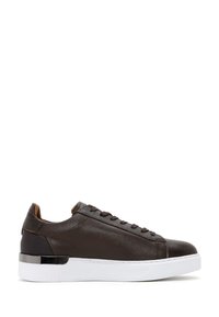 Brown leather sneaker with smooth texture, rounded toe, minimalistic lacing, and a white rubber sole. Features a metallic accent on the heel.