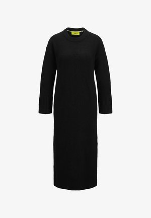 Robe en tricot noire avec un col rond, des manches longues et des poignets côtelés. Silhouette longue et droite avec une finition texturée.
