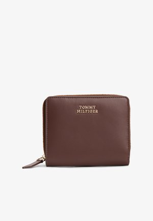 Portafoglio zip in pelle marrone con logo "TOMMY HILFIGER" in tono oro, forma rettangolare, texture liscia e chiusura con zip per un accesso sicuro.