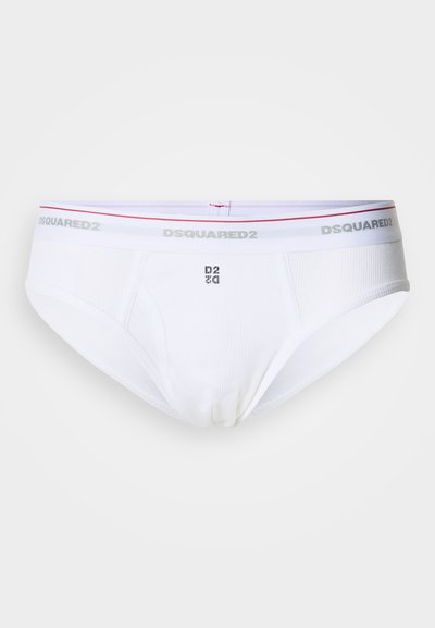 Culottes blanches en coton avec une texture côtelée, dotées d'une ceinture argentée avec logo et d'une bande rouge. Le devant présente un logo imprimé discret.