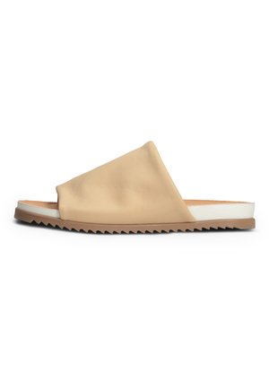 Beige leather slide sandal with an asymmetrical design, white midsole, and zigzag patterned outsole for added grip and style.