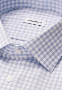 Camicia a scacchi Gingham con motivi azzurri e bianchi, tessuto di cotone, colletto a punta e due bottoni bianchi davanti.