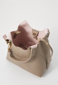 Beige leather handbag with a textured surface, pink interior, gold hardware, and a magnetic snap closure. Includes short handles and shoulder strap.