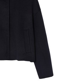 Giacca in misto lana color navy con vestibilità rilassata, dotata di tasca laterale, maniche ampie e un design pulito e minimalista.