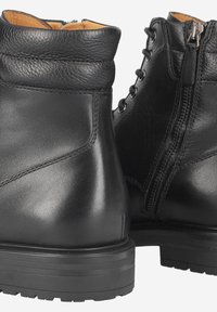 Bottines en cuir noir à finition lisse, bout rond, lacets à l'avant et fermeture éclair latérale pour un accès facile. Détail de col texturé.