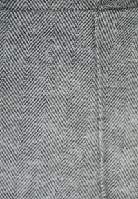 Szary materiał w rybiej łuskę z diagonalnym wzorem, z delikatnymi liniami i teksturowaną powierzchnią. Splot oferuje subtelny, wyrafinowany wzór.