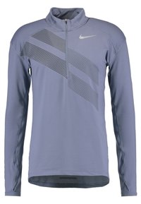 Lila långärmad sportpull med dragkedja i halsen och texturerade diagonala randmönster. Slätt tyg med ett nätinslag vid fållen.