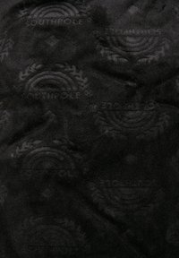 Sort stof med et tekstureret mønster med præget logoer og designs, der giver en taktil kvalitet og ensartet udseende.