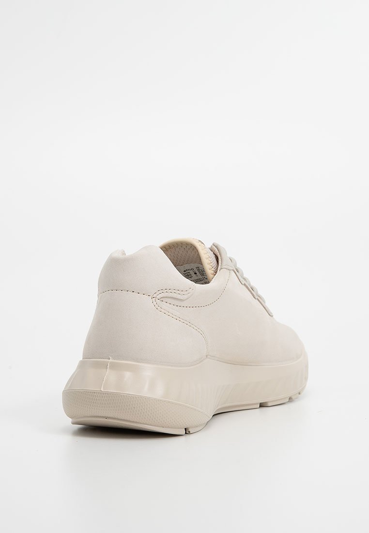 Beżowe buty sportowe z gładką zamszową cholewką, zaokrąglonym noskiem i formowaną gumową podeszwą. Posiadają system sznurowania oraz subtelne detale w szyciu.