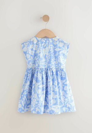 Blaues Blumenkleid mit kurzen Ärmeln, gerafftem Rock und weißem Blumenmuster. Aus leichtem Stoff gefertigt, hängt an einem hölzernen Kleiderbügel.