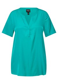 Blusa corta turchese a maniche corte con scollatura a V e vestibilità rilassata, dotata di un piccolo etichetta del marchio sulla parte posteriore del collo.