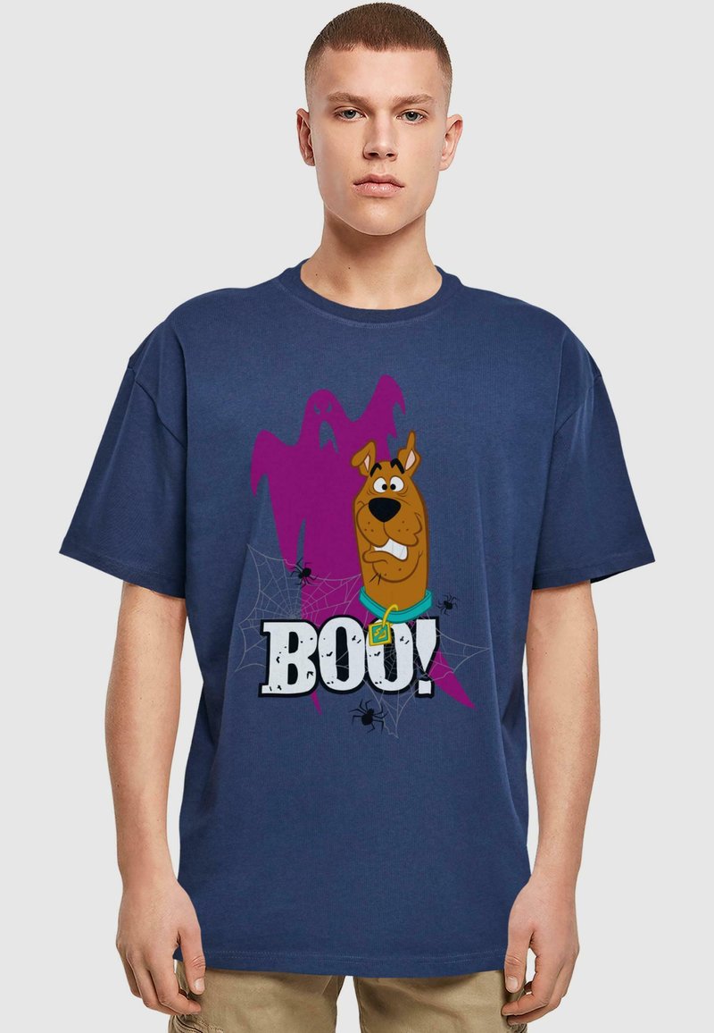 Navy blue cotton t-shirt featuring a cartoon dog next to a purple ghost. "BOO!" text in bold, with spider and web illustrations.