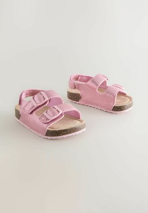 Rødeglitrende sandaler med dobbelte stropper og spænder. Blød indvendig foring og en tekstureret, mørkebrun gummisål. Letvægtsdesign.