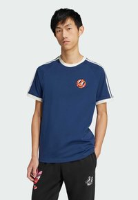 Navy blue t-shirt with white trim, featuring a round neckline and short sleeves. Embroidered orange character design on the chest.