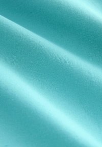 Helle blaue Stoff mit glatter Textur und leichtem Glanz, der ein gleichmäßiges Webmuster zeigt. Falten erzeugen sanfte Wellen auf der Oberfläche.
