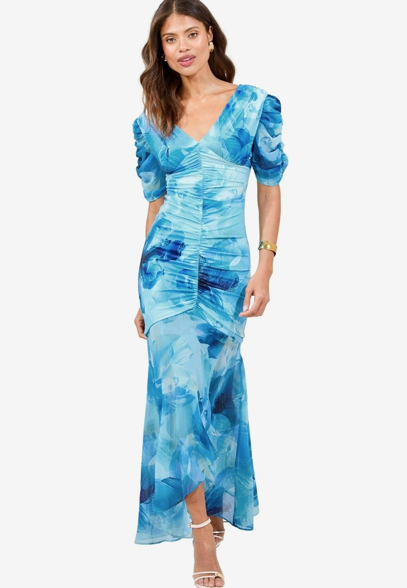 Abito maxi floreale blu con maniche a sbuffo, corsetto aderente e tessuto strutturato. Presenta un profondo scollo a V e una gonna fluente con uno spacco laterale.