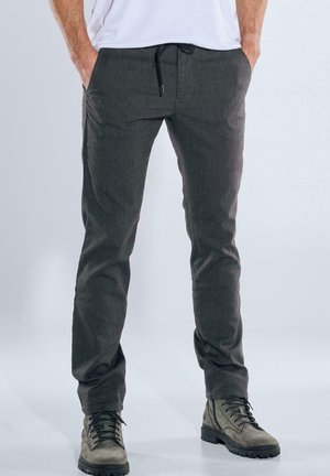 Kohlefarbene Hose aus Gewebestoff, mit einem Kordelzugbund, Seitentaschen, Slim Fit und strukturierter Oberfläche. Kombiniert mit Stiefeln.