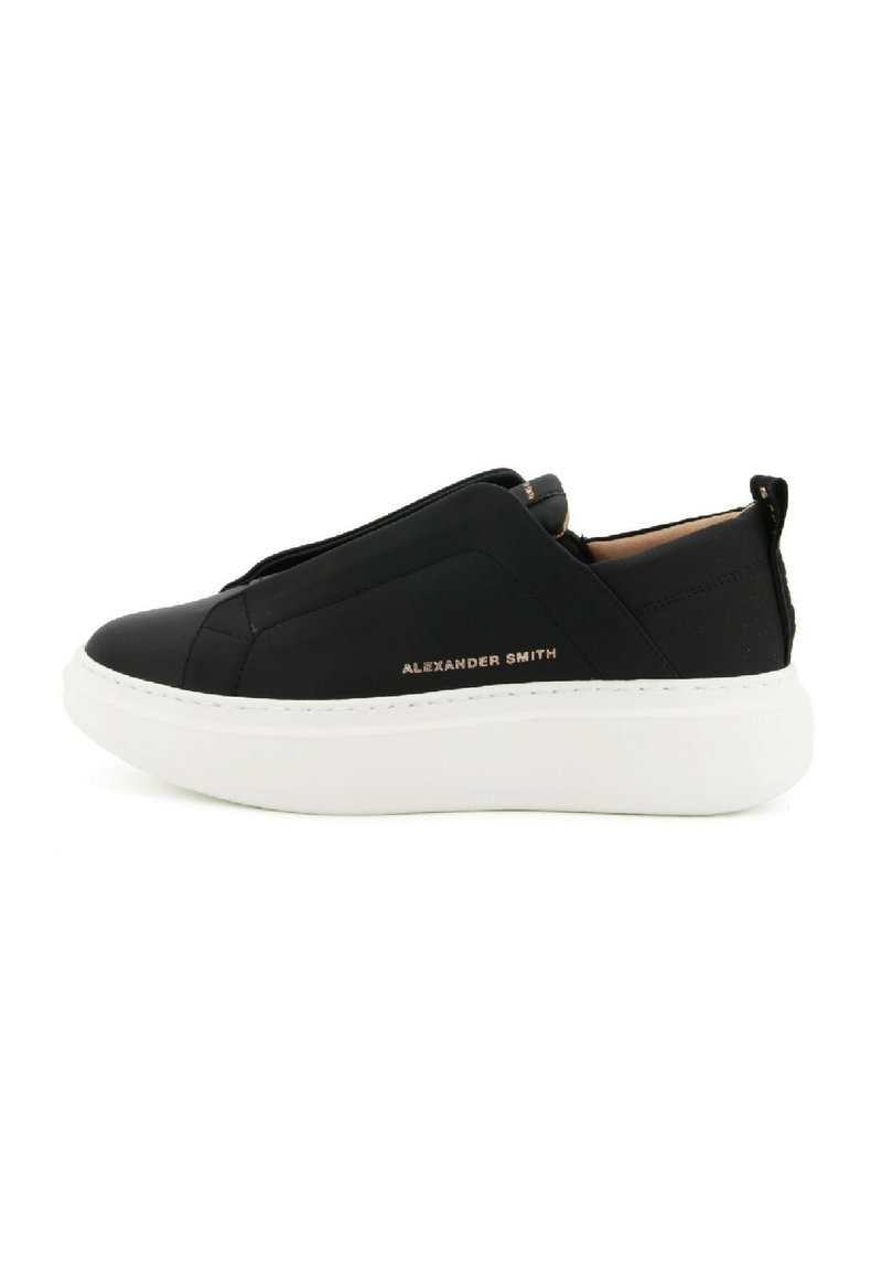 Sneaker neri slip-on con una texture liscia, suola piatta bianca e design minimalista. Presenta un marchio in rilievo sul lato.