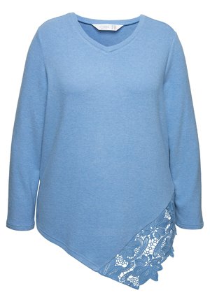 Haut à manches longues bleu clair avec un décolleté en V, présentant un panneau en dentelle texturée sur un côté et un ourlet asymétrique. Fabriqué dans un tissu doux.