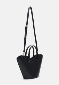 Sort læderhåndtaske med en struktureret, konisk form, der har to topgreb og en justerbar skulderrem. Glat tekstur, minimal detailing.