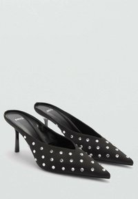 Mustat slingback-korkokengät, joissa on terävät varpaat, varustettu hopeisilla niiteillä, ohut korko ja pehmeä kankaan tekstuuri.