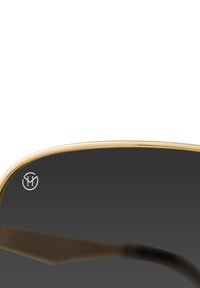 Zwarte zonnebril met een gouden metalen frame, voorzien van een gebogen bovenrand en een logo dat op de lens is gedrukt. Gladde textuur met reflecterende afwerking.