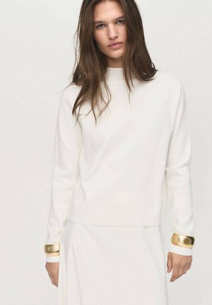 Maglione bianco con scollo rotondo, dotato di maniche lunghe e dettagli dorati ai polsini. Texture morbida, design minimalista.