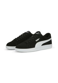 Zapatillas de ante negras con acentos blancos, diseño de cordones, punta redondeada y suela texturizada; presenta el logo de Puma en los laterales y en la lengüeta.