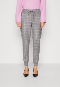 Checked trousers in grey, featuring a drawstring waistband and elastic cuffs. Smooth fabric with a subtle sheen and side zip pockets.