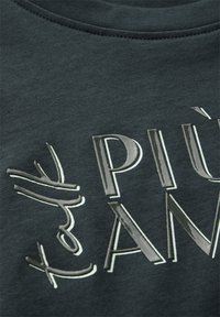 Tmavě zelená bavlněná mikina s vyvýšenými metalickými písmeny, která tvoří nápis "PIÙ AMORE" s texturovaným povrchem. Kulatý výstřih a měkká tkanina.