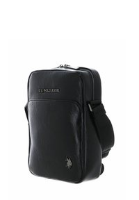 Sac bandoulière en cuir noir avec fermeture éclair, doté d'une poche avant et du logo U.S. Polo Assn. embossé sur le devant.