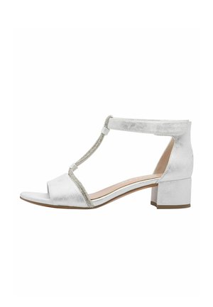 Sandales blanches métalliques à talon bloc avec design en T, présentant une finition texturée et une décoration de strass le long de la bride.